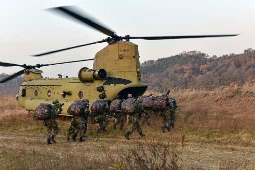 Military helicopter flying above a military base during a mission.