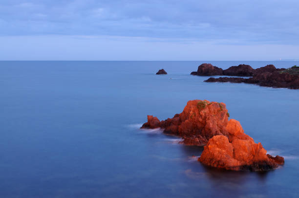 Agay Bay: a rock at sunset illuminated by the red light of the sun
