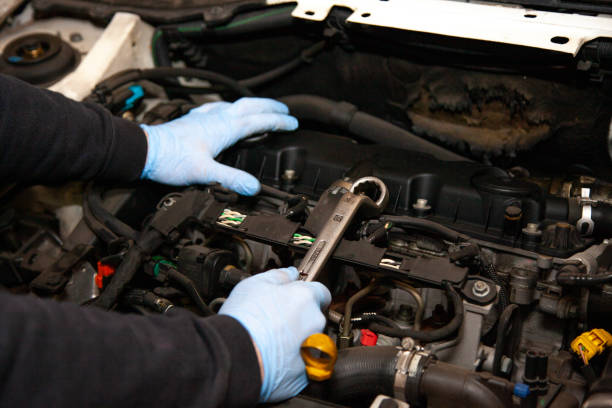 istock Mechanic repairs cars in his workshop using various tools 1078421780