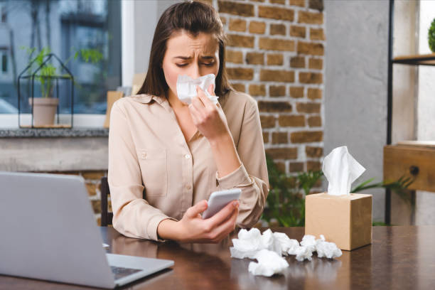 istock young businesswoman using smartphone and suffering from allergy at workplace 1078425292