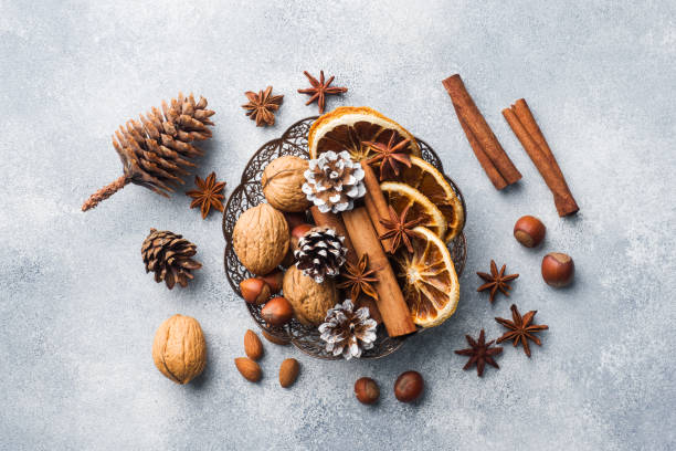 istock Winter food ingredients nuts cones oranges cinnamon star anise in a bowl. Rustic style. 1078429558
