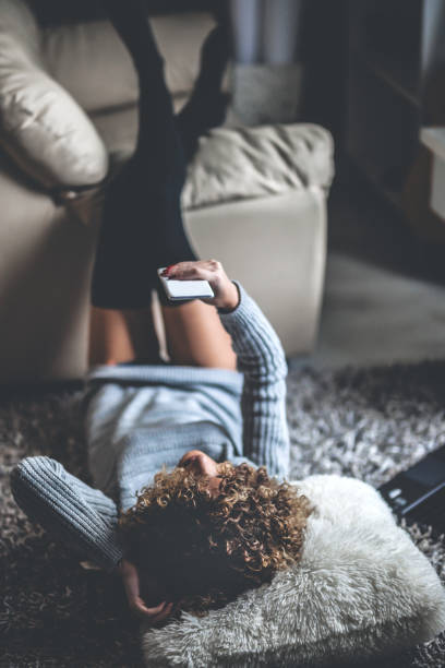 istock Young woman on sofa using mobile phone 1078430862