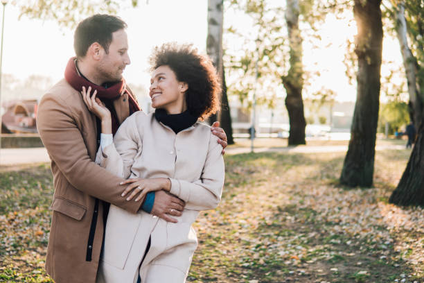 istock Happy young couple embracing in a park 1078433642