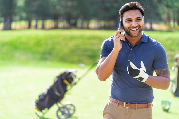 istock Male golfer standing on golf course and talking on a smart phone 1078434110