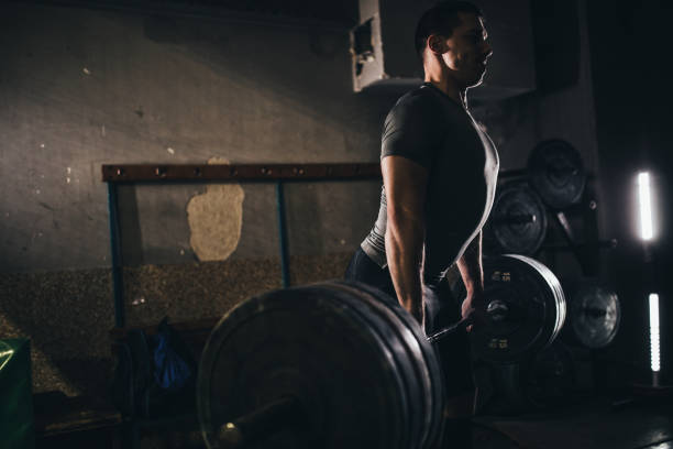istock Guy weightlifting in dark gym 1078443350
