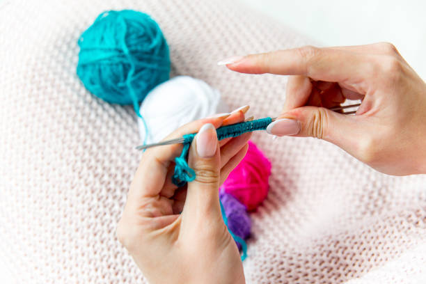 istock Female hands knitting with wool, top view 1078447056