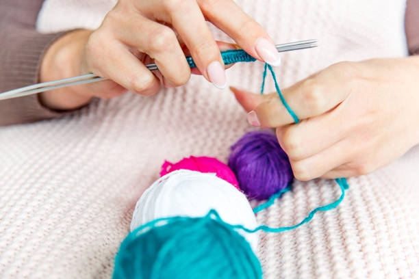 istock Female hands knitting with wool, top view 1078447122