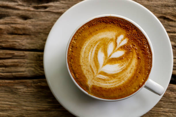 istock Hot cofffee cup on wooden with painting leaf 1078448604