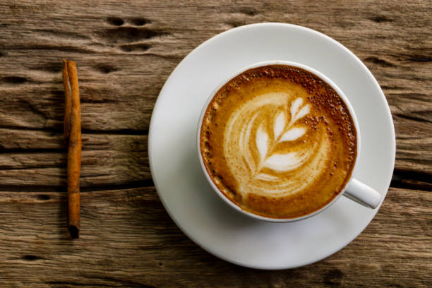 istock Hot cofffee cup on wooden with painting leaf 1078448606