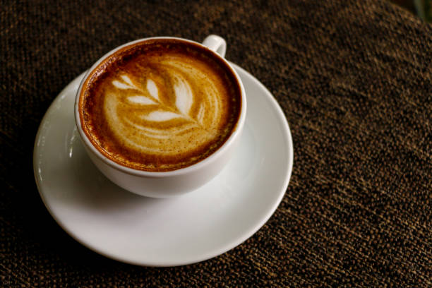 istock Hot cofffee cup on wooden with painting leaf 1078448656