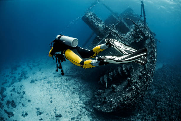 黄色に赤い海の下で草に覆われた難破船を探検スキューバダイバーが適しています - shipwreck ストックフォトと画像