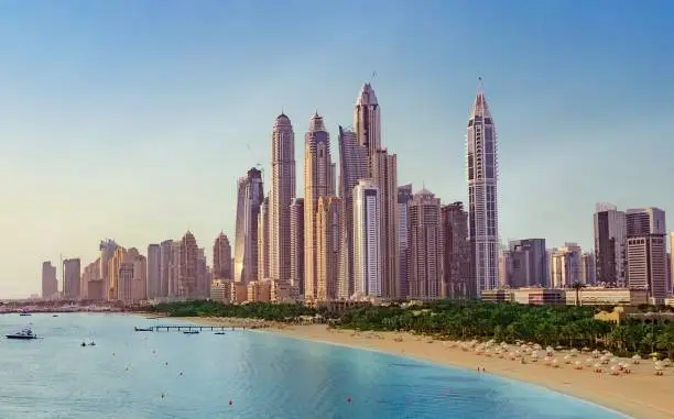 Photo of beautiful Dubai Skyline view at day with Ocean wave. luxury travel holiday concept.