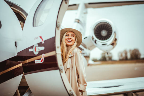 istock Young rich woman entering a parked private airplane 1078453604