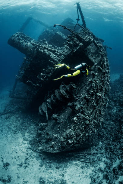 istock Scuba diver observing a large shipwreck completely rusted and overgrown lying underwater in the Red Sea 1078455998