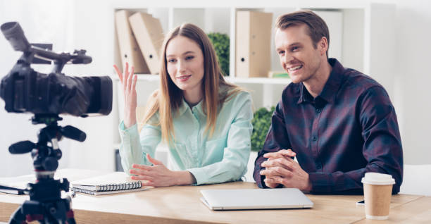 istock smiling video bloggers recording vlog and gesturing in office 1078467650