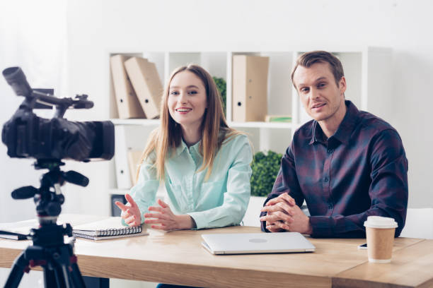 istock smiling video bloggers recording vlog at table in office 1078467658