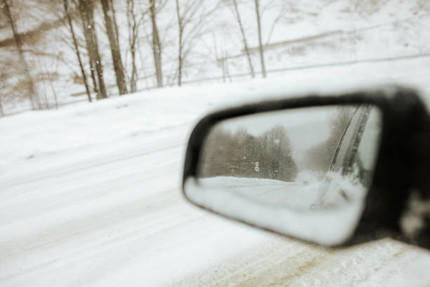istock Snowy road in the car mirror 1078474346