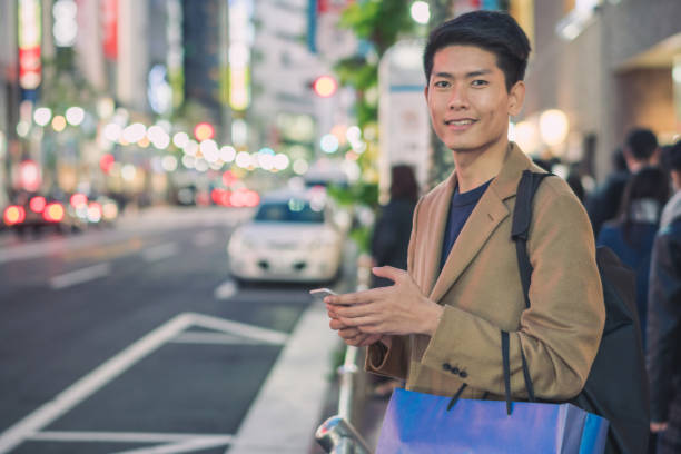 istock Young asian man using cellphone and looking for christmas gift while shopping for christmas in mall or department store Japan 1078478000