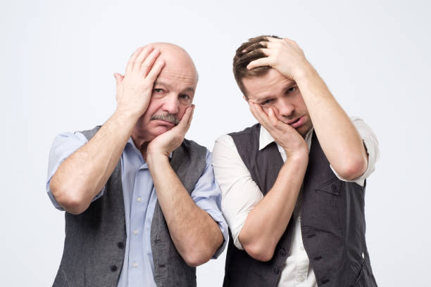 istock Annoyed tired men leaning face on hand and looking indifferent at camera, standing bored 1078482058