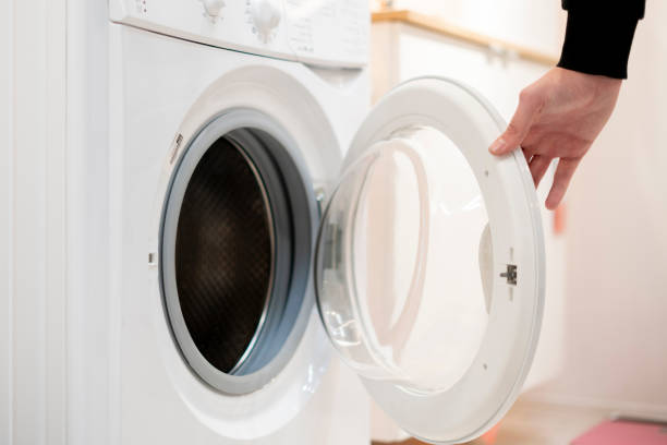 close up hand launch set and start washing machine laundry at home bathroom b close up hand launch set and start washing machine laundry at home bathroom washing machine drum stock pictures, royalty-free photos & images