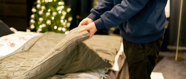 istock close up young man making a bed at home bedroom v 1078489728