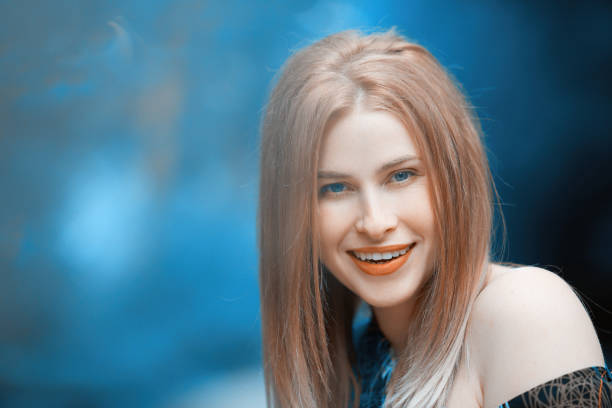 attractive blond hair woman in nature looking at camera and enjoying summer day in the forest.