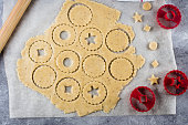 Process traditional Christmas cookies. Raw dough and cutters for the holiday cookies on light table. Preparing Christmas Linzer Cookies. Steps of making biscuits. Top view.