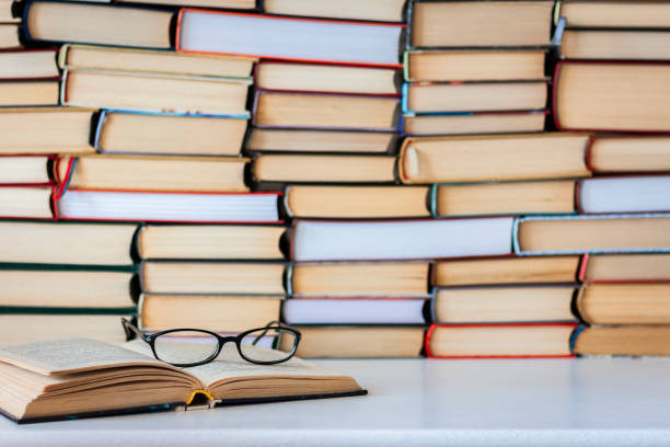 istock Books background, glasses and notebook on white wooden table 1078504904