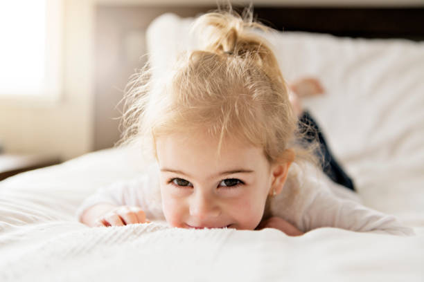 istock young daughter two years old relaxing in bed, positive feelings 1078508276