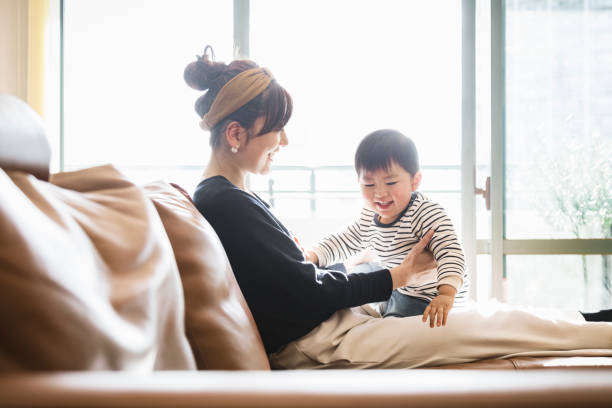 母親と赤ちゃんがソファでリラックス - 家族 日本人 ストックフォトと画像