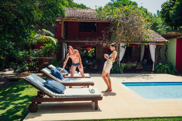 istock Couple by poolside with sun loungers 1078521774
