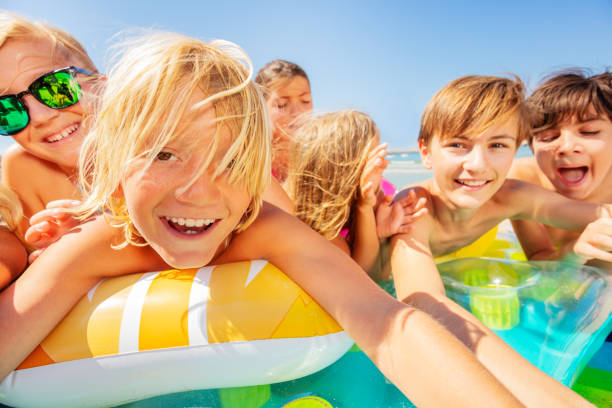 istock Cute boy taking selfie with friends on the beach 1078526384