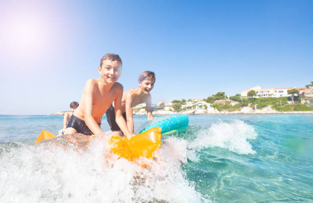 istock Active boys learning to ride the waves at seaside 1078526610