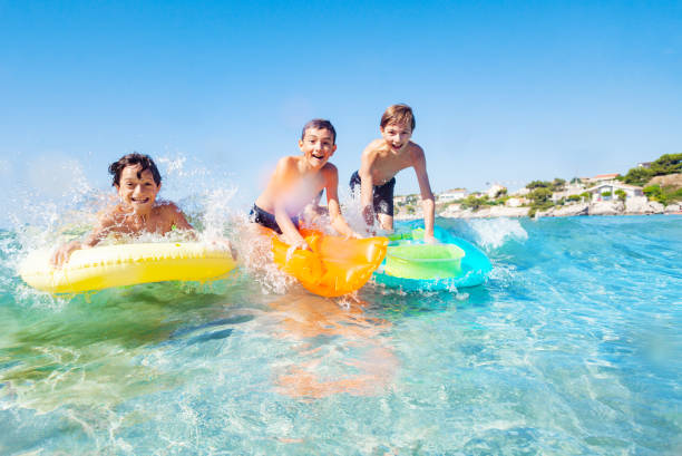 istock Three happy friends surfing the beach waves 1078526614