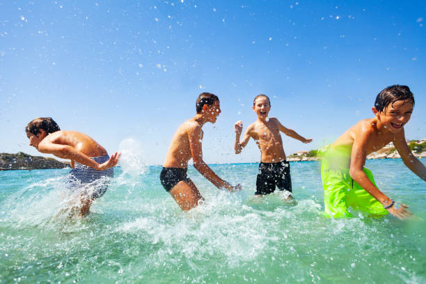 istock Four happy boys playing at tropical shallow water 1078526714