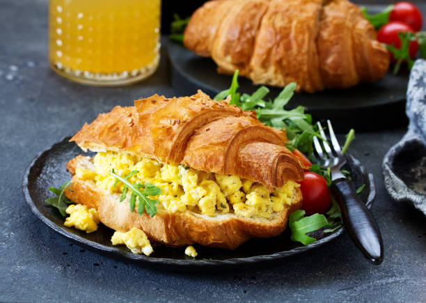 istock Breakfast of croissant with scrambled eggs and salad. 1078536156
