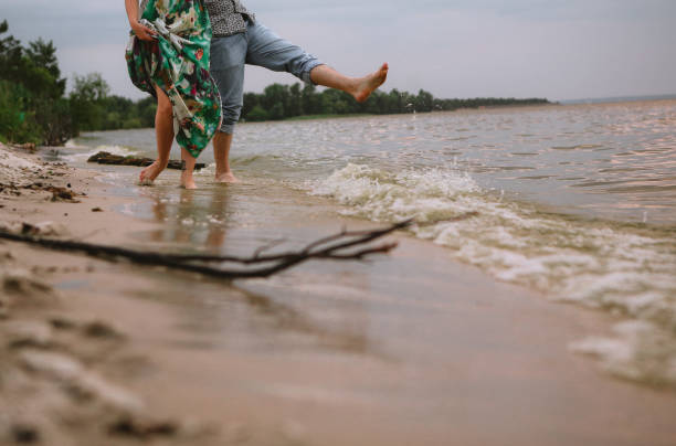 istock couple play shore water splashes love clothes 1078537344