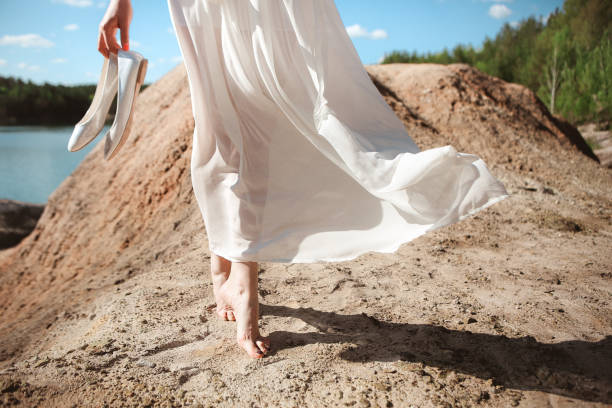 istock girl dress white wind bare sand sky 1078537448
