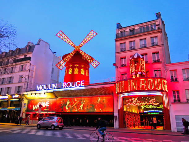 PARIS The Moulin Rouge on  pink sunset  in Paris, France. Picturesque Old facade building of famous cabaret built in 1889, locating in the Paris red-light district Pigalle PARIS The Moulin Rouge on  pink sunset 11.01.2015. in Paris, France. Picturesque Old facade building of famous cabaret built in 1889, locating in the Paris red-light district Pigalle place pigalle stock pictures, royalty-free photos & images