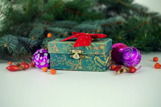 A gift in green box. Composition with fir branches, red berries, Christmas decorations and snow stock photo