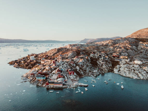 Fishing village in East Greenland This panorama photo shows a fishing village in the bay of Tasiilaq in East Greenland from above at sunset. greenland photos stock pictures, royalty-free photos & images
