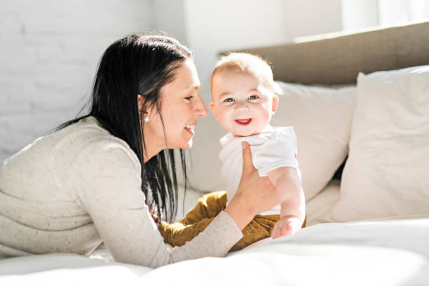 istock Mother with a baby on bed at home 1078557390