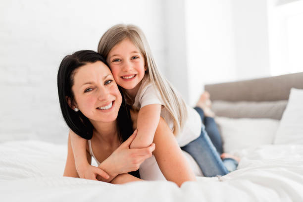 mãe e filha desfrutar na cama em casa - oneparent - fotografias e filmes do acervo