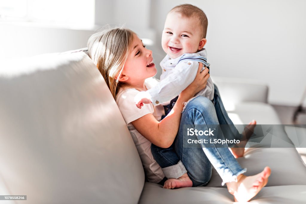 Little sister with her baby brother. Toddler kid Family with children at home. A Little sister with her baby brother. Toddler kid Family with children at home. Sibling Stock Photo