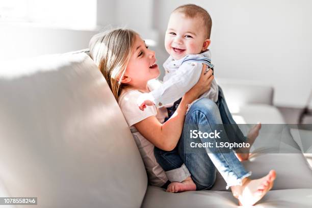 Little Sister With Her Baby Brother Toddler Kid Family With Children At Home Stock Photo - Download Image Now