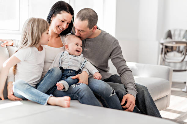young family at home having fun on sofa
