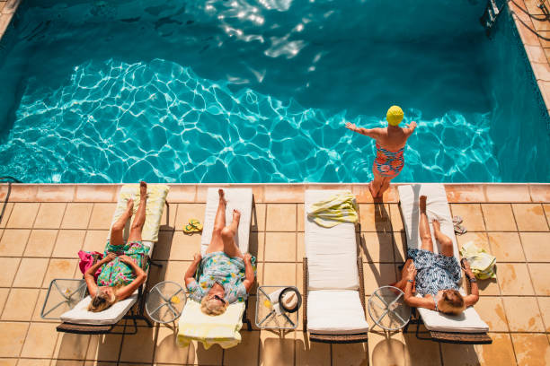 femmes âgées détente en vacances - active seniors retirement enjoyment swimming pool photos et images de collection