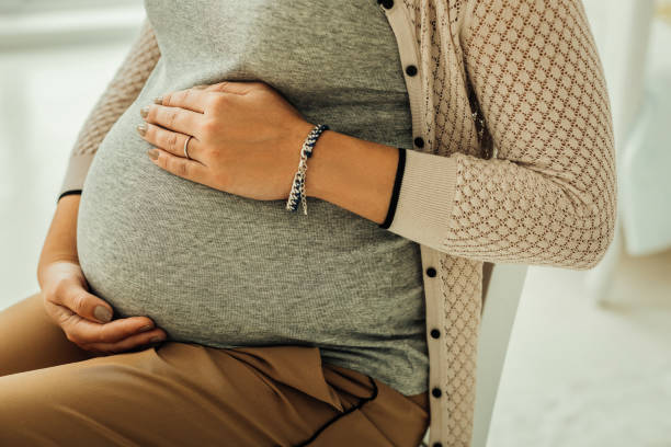 istock Young woman touching her third-trimester pregnant belly 1078568650