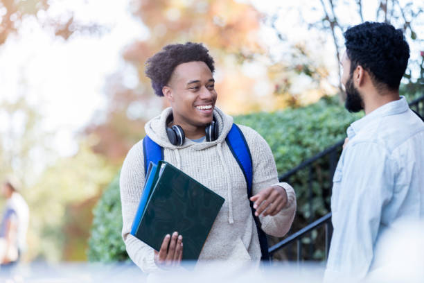 istock Male college student enjoys conversation with friend 1078571656