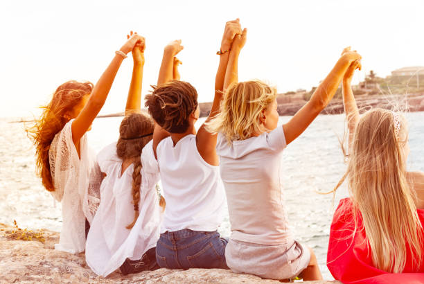 istock Friends holding hands and looking at the seascape 1078572478